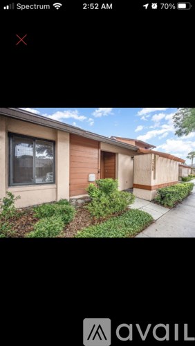 A mobile phone displaying a photo of a house with a red cross on the top left corner.