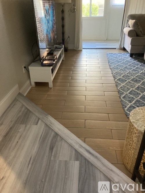A living room with a white couch and a wooden floor.