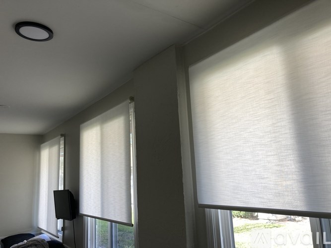 A room with a ceiling light and a window with blinds.