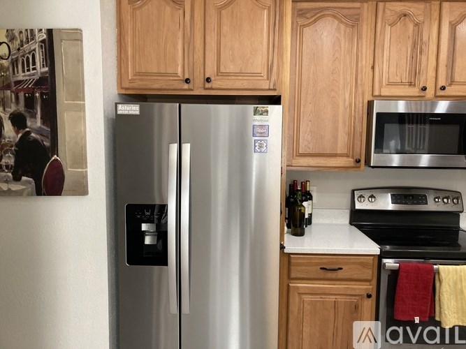 A kitchen with a refrigerator, microwave, and oven.