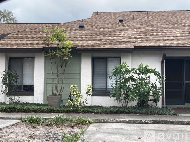 A house with a green door and a tree in front.