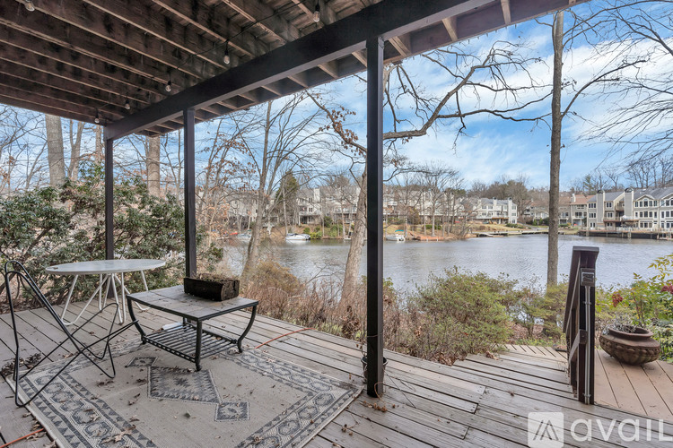 A balcony with a table and chairs overlooking a body of water.