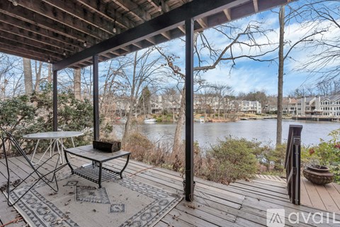 A balcony with a table and chairs overlooking a body of water.