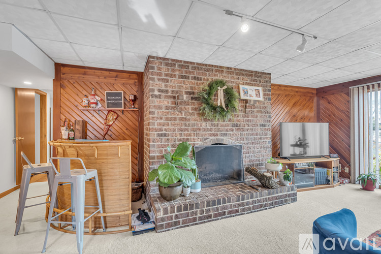 A living room with a fireplace and a wreath on the wall.