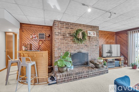 A living room with a fireplace and a wreath on the wall.