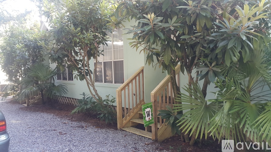 A house with a wooden gate and a car parked in front.