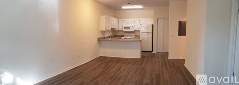 A kitchen area with white cabinets and a countertop.