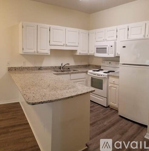 A kitchen with white appliances and cabinets.