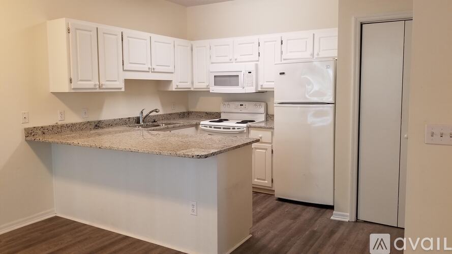A kitchen with white appliances and cabinets.