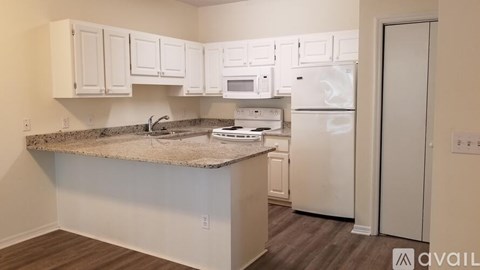 A kitchen with white appliances and cabinets.