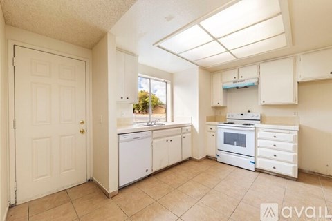 A kitchen with white appliances and cabinets.