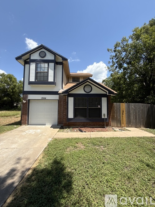 A two-story house with a garage on the first floor and a balcony on the second floor.