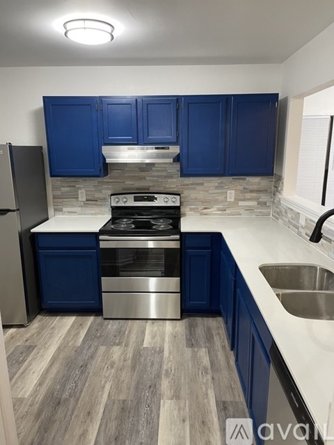 A kitchen with blue cabinets and a stainless steel stove.