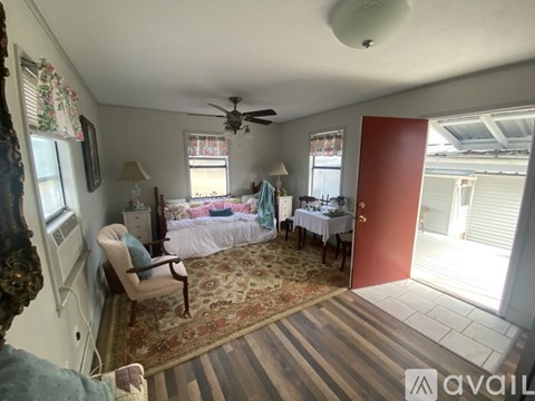 A living room with a couch, chairs, and a dining table set up.