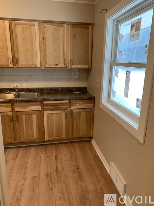 A kitchen with wooden cabinets and a window.