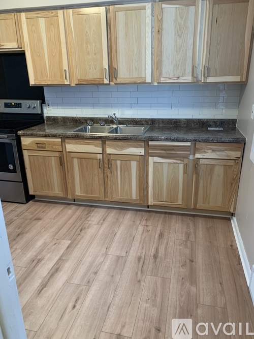 A kitchen with wooden cabinets and a black oven.