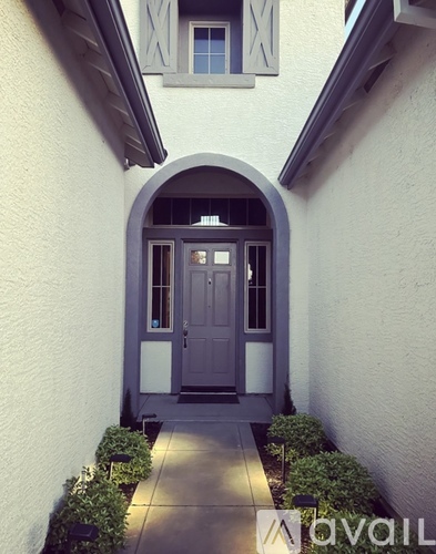 A grey door is in a white building.