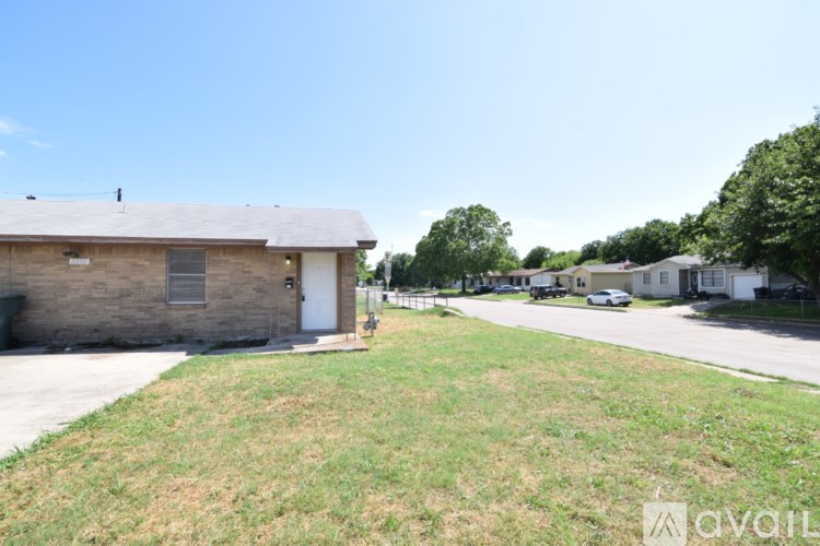 A grassy area in front of a building with a sign that says "available".