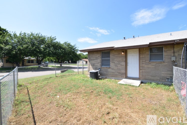 A house with a fence and a tree in front of it.