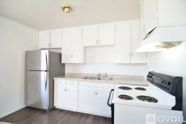 A kitchen with white cabinets and a stainless steel refrigerator.