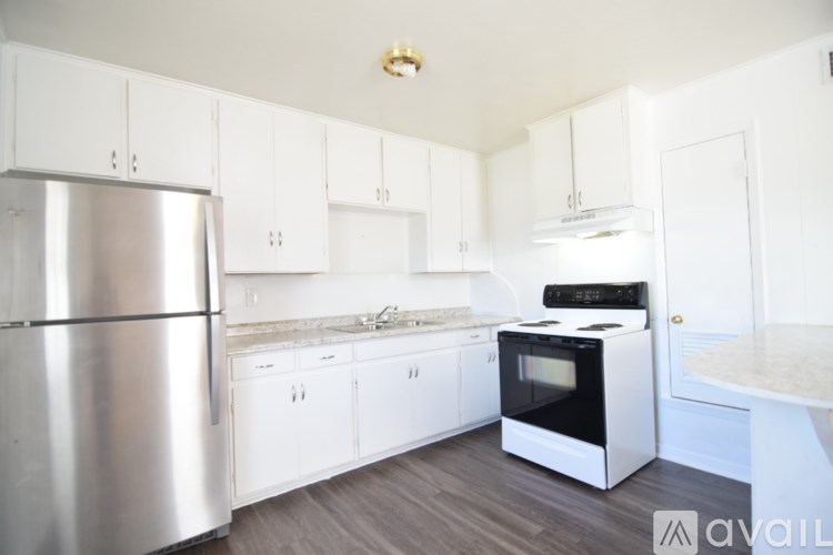 A kitchen with white cabinets and a stainless steel refrigerator.
