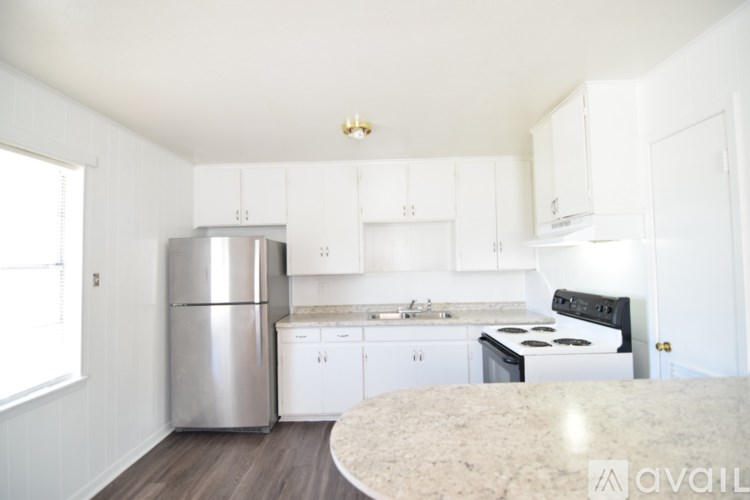 A kitchen with white cabinets and a marble countertop.
