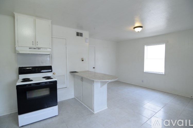 A kitchen with a black stove top oven and white cabinets.