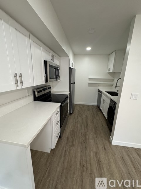 A kitchen with white cabinets and a black stove top oven.