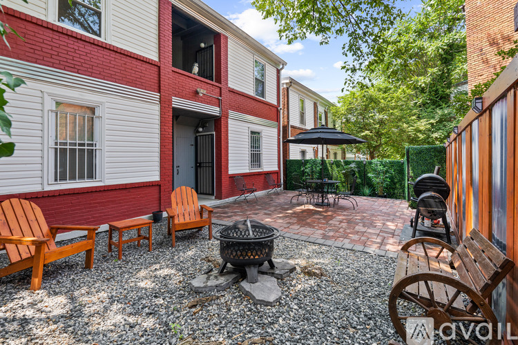 A patio with a fire pit and chairs.