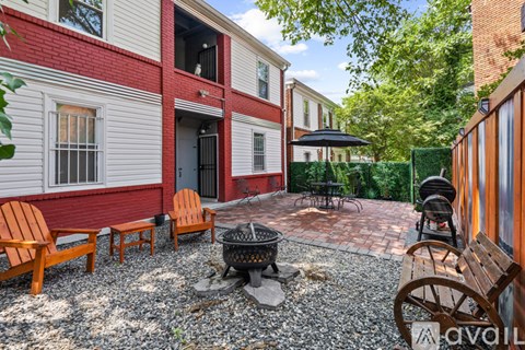 A patio with a fire pit and chairs.