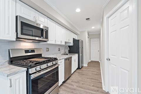 A kitchen with white cabinets and a black stove top oven.