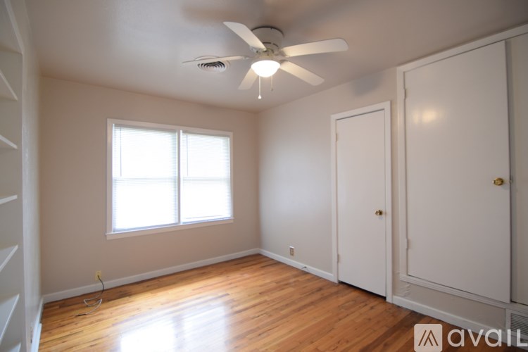 A room with a ceiling fan and two doors.