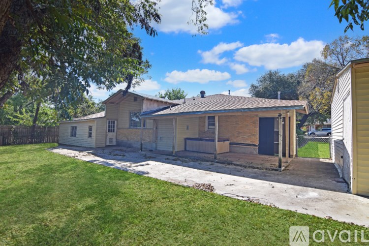 A house with a white siding and a brown roof is surrounded by a green lawn.