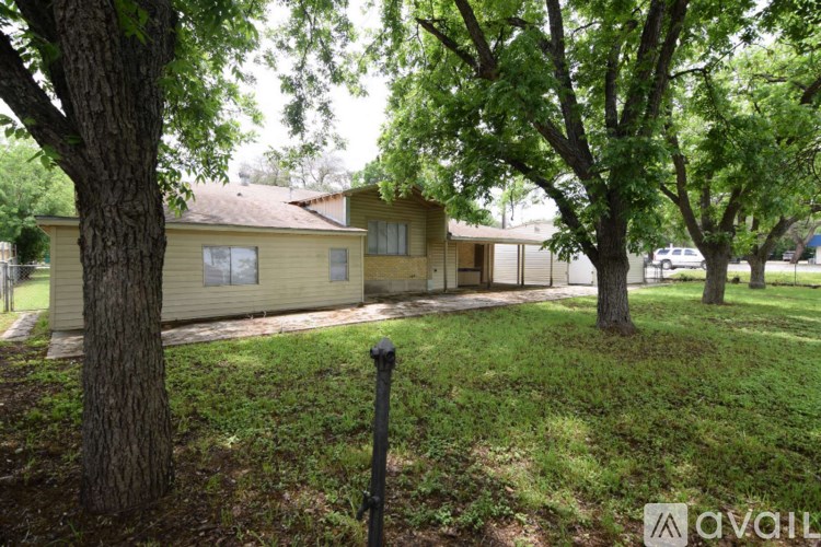 A backyard with a concrete path and a fence.