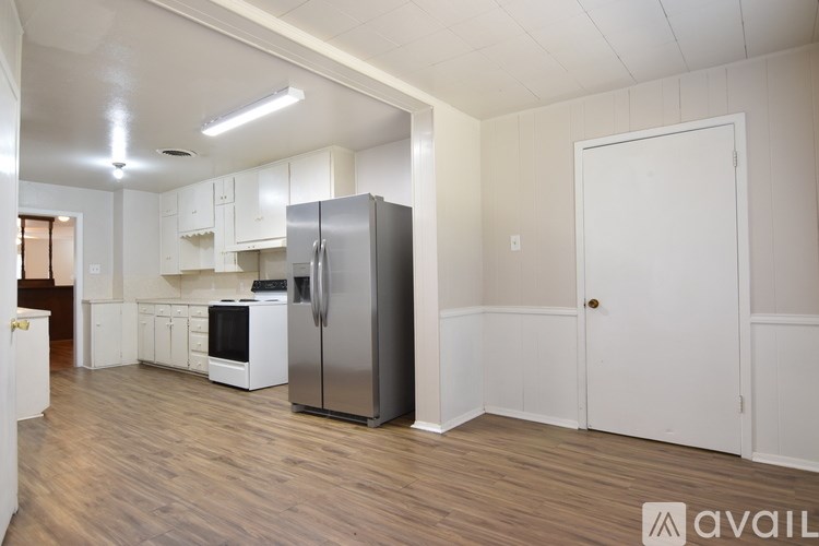 A kitchen with wooden floors and white cabinets.