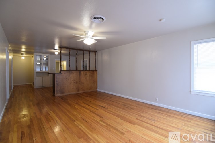 A room with wooden floors and a ceiling fan.