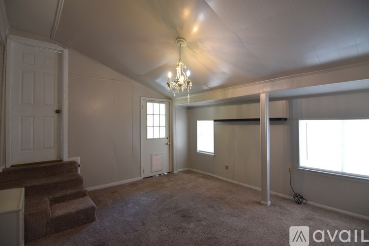 A room with wooden floors and a white cabinet with glass doors.
