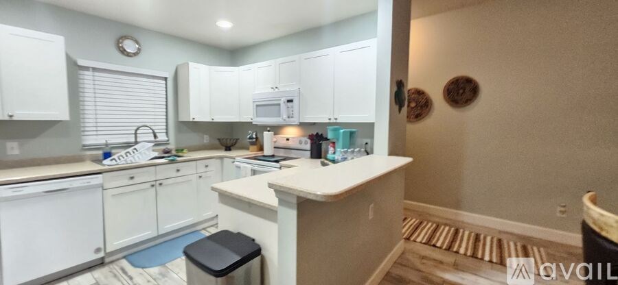 A kitchen with white cabinets and a white island.