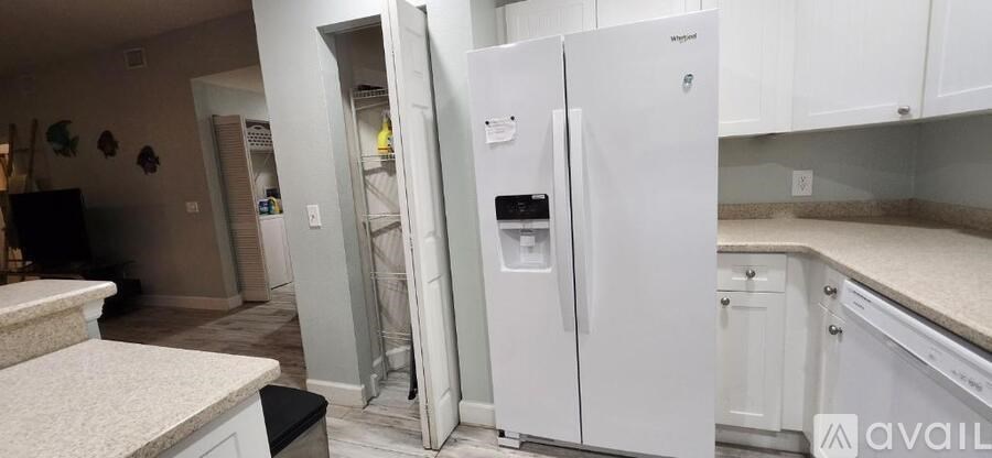 A white refrigerator with a water and ice dispenser in a kitchen.