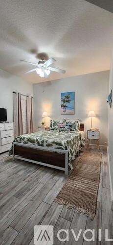 A bedroom with a bed, nightstands, and a ceiling fan.