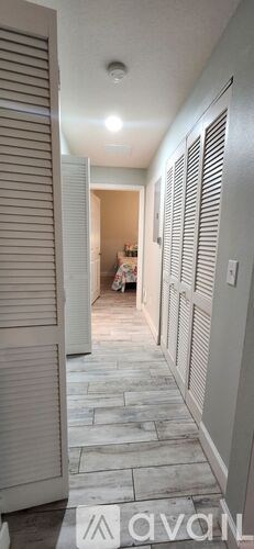 A hallway with a tiled floor and white walls.