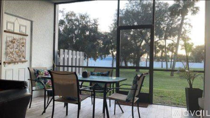 A patio with a table and chairs overlooking a body of water.