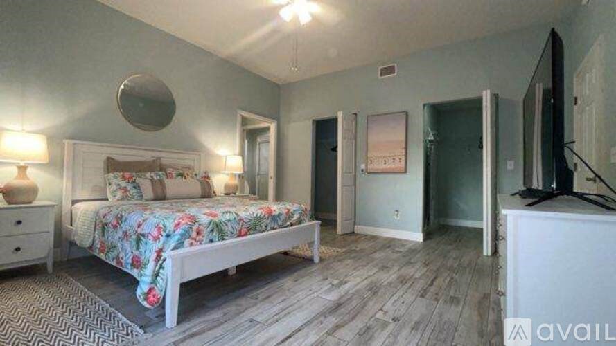 A bedroom with a bed, dresser, and mirror.