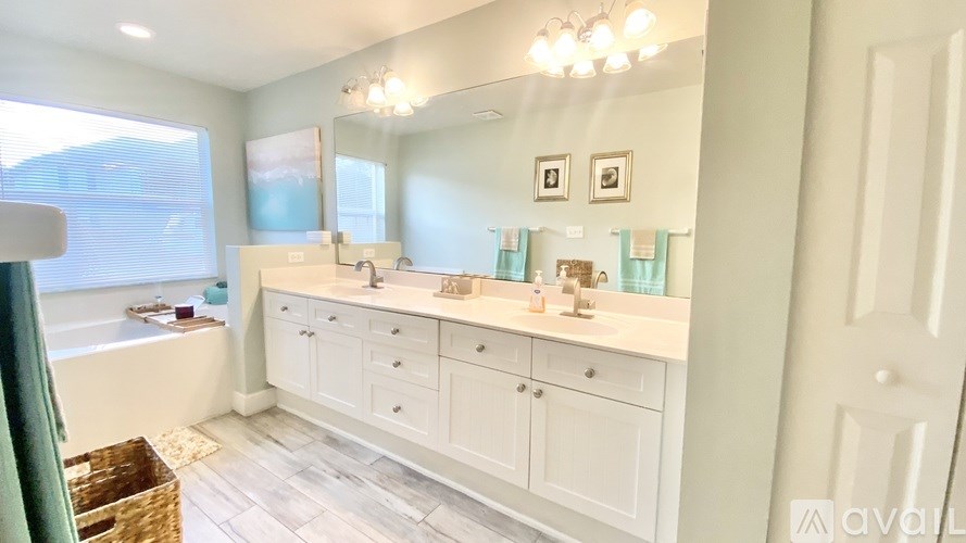 A bathroom with a large mirror and a tub.