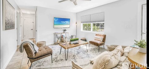 A living room with a flat screen TV mounted on the wall.