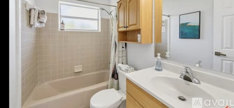 A bathroom with a tub, toilet, and sink.