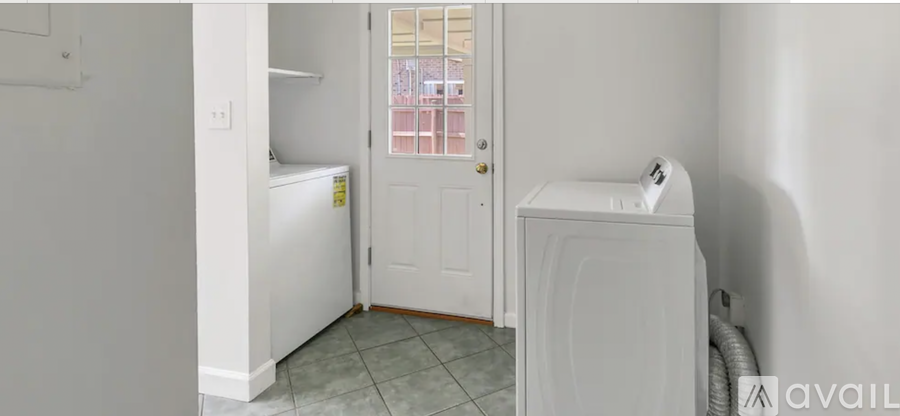 A small white bathroom with a toilet and a washing machine.