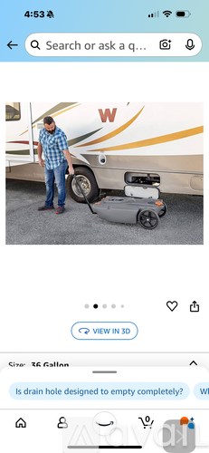 A man is standing next to a white RV with a robotic vacuum cleaner in front of it.