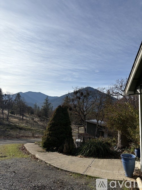 A house with a mountain in the background and a clear sky.