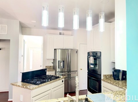 A kitchen with a granite countertop and stainless steel appliances.